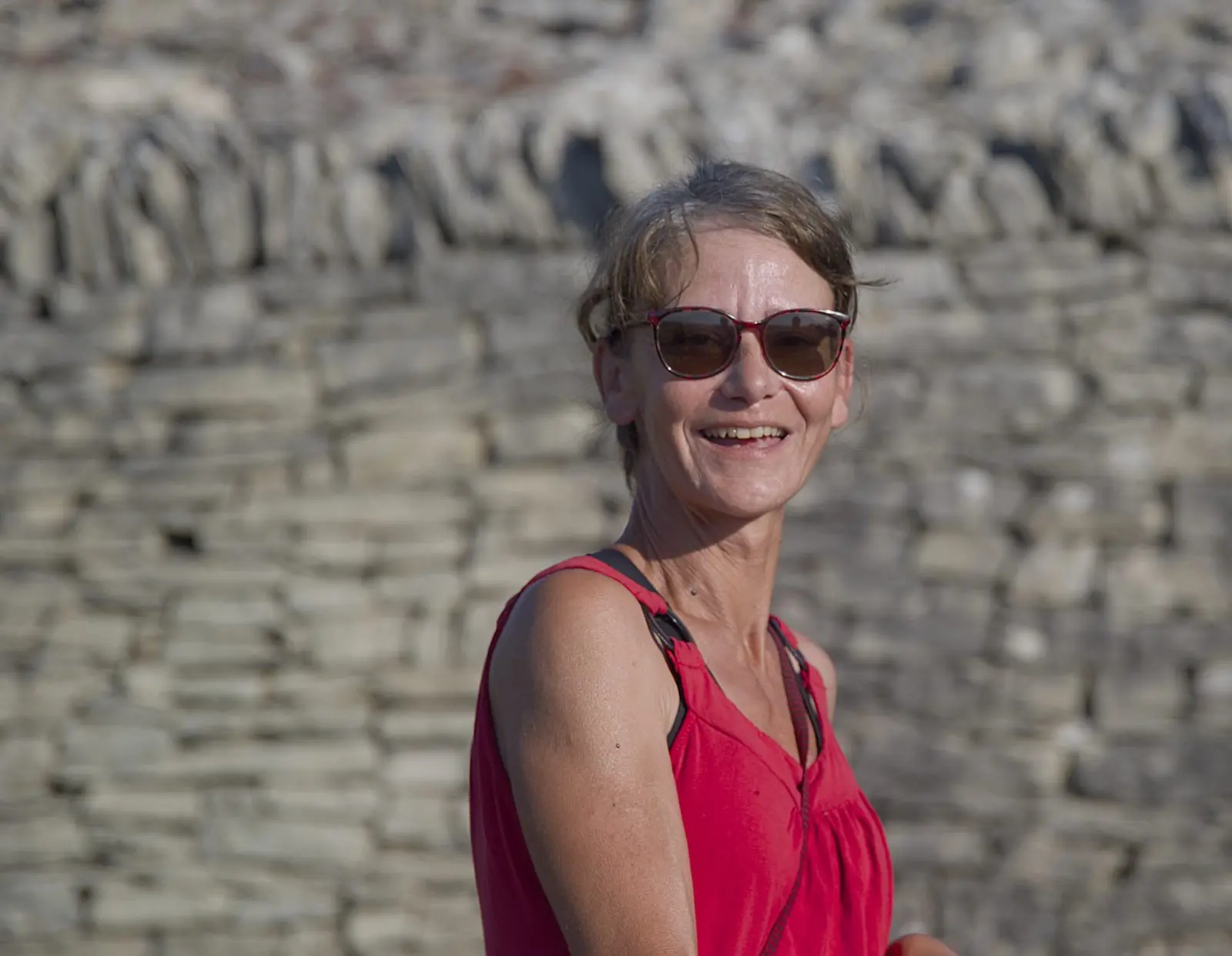 Céline, votre guide, au pied d'un mur en pierres sèches